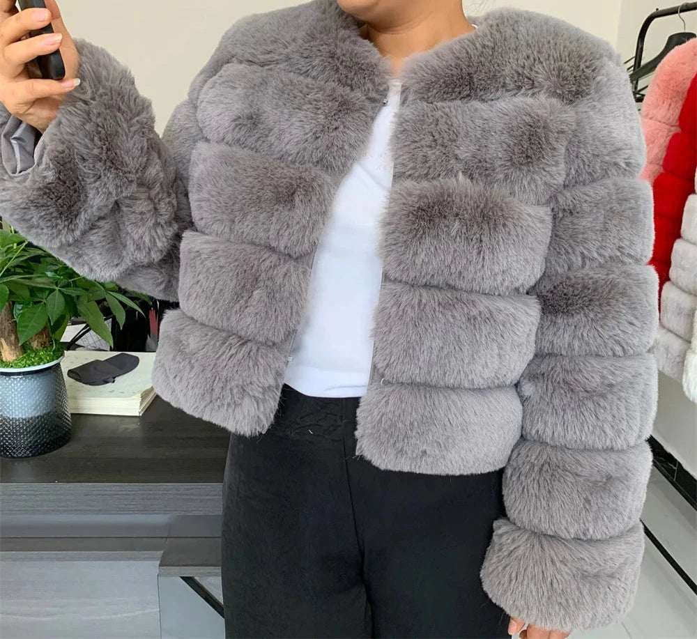 "Amoura Elegance women’s short faux fur coat in elegant grey, crafted from plush faux fox fur with full sleeves and a comfortable 60 cm length, available in size XXXXL for a chic and stylish look."