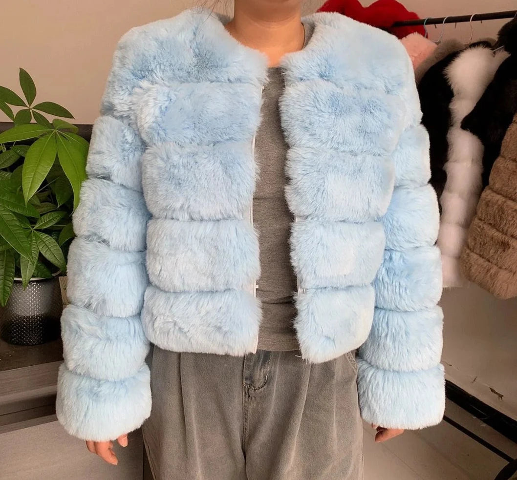 "Amoura Elegance women’s faux fur coat in a serene sky blue, designed for autumn and winter. This high-quality, 60 cm jacket features plush faux fox fur and elegant full sleeves, combining style and warmth. Available in size XXXXL, it’s a sophisticated choice for any wardrobe."